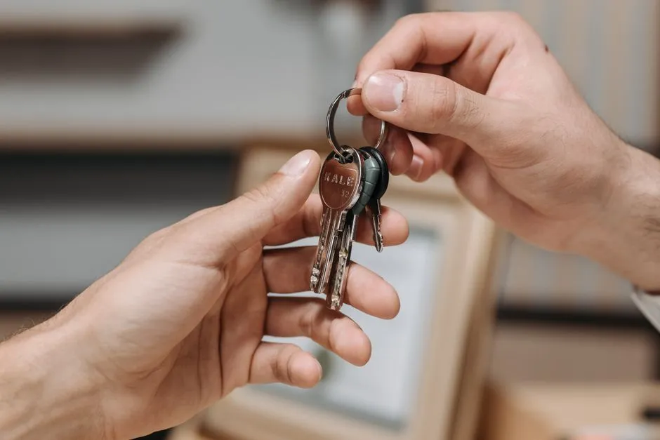 Close-up of two hands exchanging a set of keys, illustrating a vehicle handoff